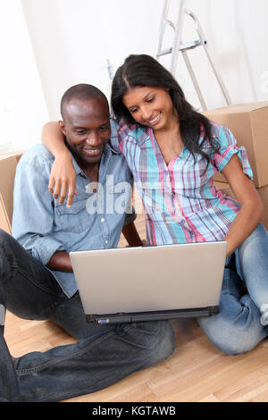 Couple using laptop computer in their new house Stock Photo
