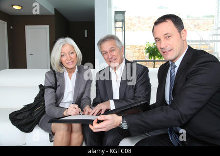 Senior couple signing financial contract for property purchase Stock Photo