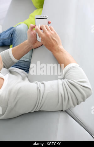Upper view of man in sofa using smartphone Stock Photo
