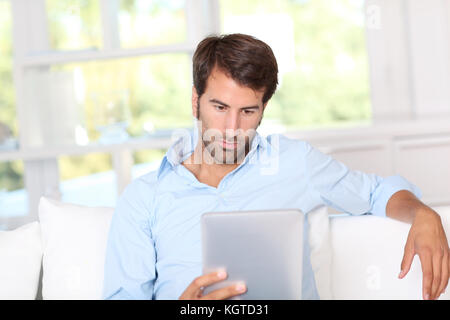 Handsom guy using electronic tablet at home Stock Photo