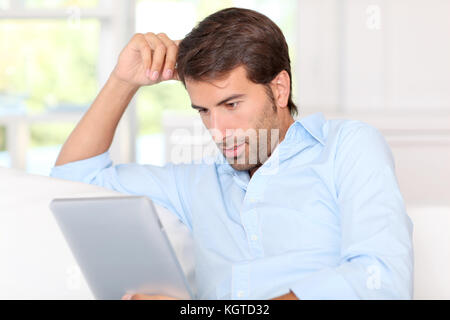 Handsom guy using electronic tablet at home Stock Photo