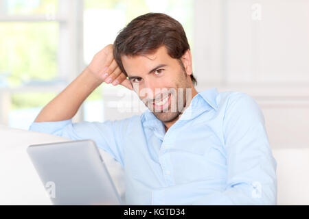Handsom guy using electronic tablet at home Stock Photo