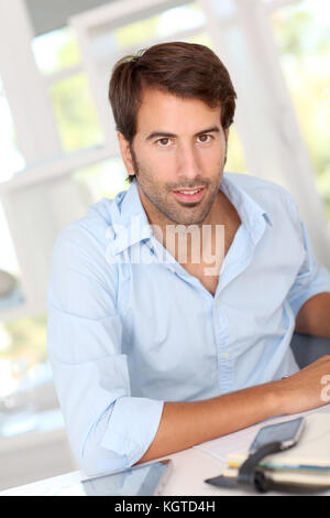 Man working on electronic tablet in office Stock Photo