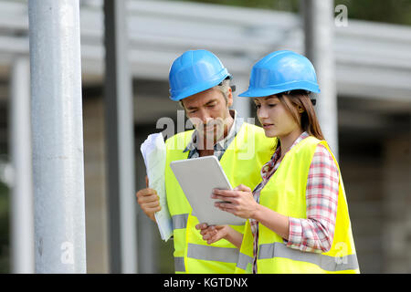 Construction people using electronic tablet on site Stock Photo