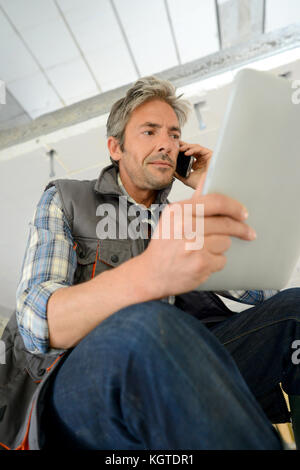 Construction manager using mobile phone on building site Stock Photo