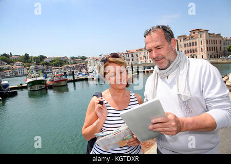 Senior couple using digital tablet to find city tour Stock Photo