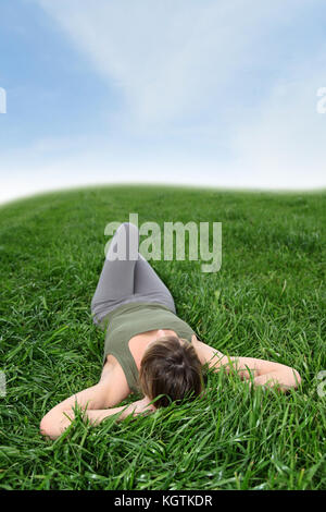 Beautiful woman resting in a green field Stock Photo