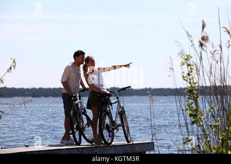 Couple standing on a bridge with bicycles Stock Photo