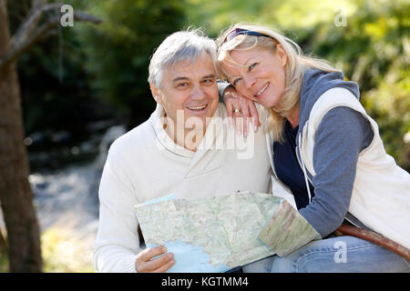 Closeup of happy senior couple sitting by river Stock Photo