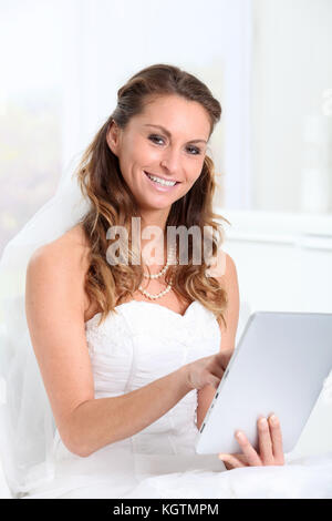 Beautiful bride websurfing on electronic tablet Stock Photo