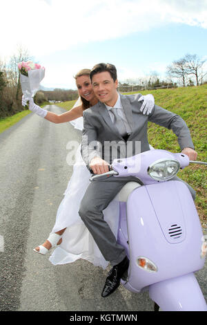 Married couple riding motorcycle on their wedding day Stock Photo