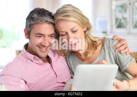 Couple at home using electronic tablet Stock Photo