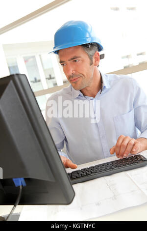 Engineer in office working on construction plan Stock Photo