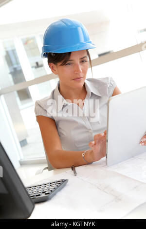 Smiling woman architect in office working with electronic tablet Stock Photo