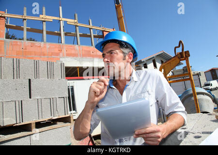 Construction manager using electronic tablet on building site Stock Photo