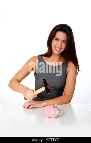 Young woman ready to break piggy bank with hammer Stock Photo
