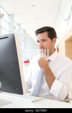 Salesman in front of desktop computer Stock Photo