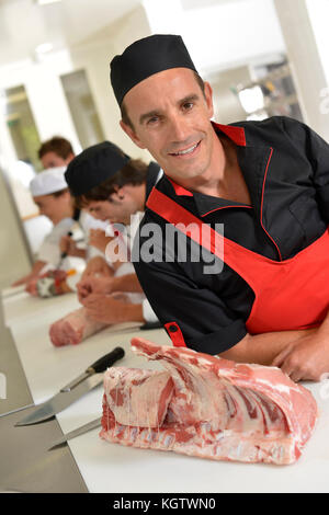 Portrait of smiling butcher standing in kitchen Stock Photo
