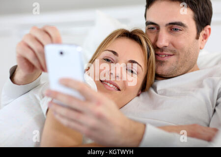 Couple laying in sofa and using spartphone Stock Photo