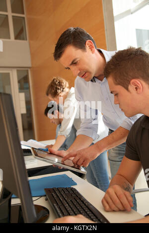 Educator helping student in training class Stock Photo
