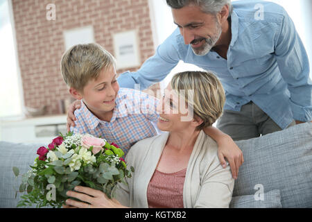 Young boy giving flowers to mommy for mother's day Stock Photo