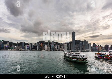 HONG KONG, CHINA - JUNE 20, 2017:A Star ferry crosses the Victoria harbor between the Kowloon pier and Central in Hong Kong island during sunset. The  Stock Photo