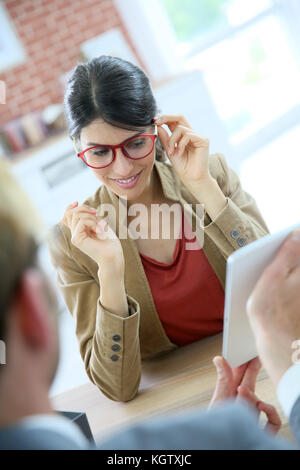 Woman in optical store choosing eyeglasses Stock Photo