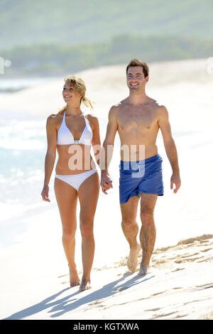 Young couple walking on paradisiacal beach Stock Photo