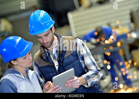 Engineers in steel factory working on digital tablet Stock Photo
