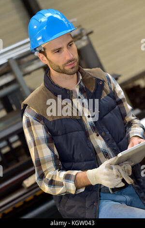 Man in manufacture using digital tablet Stock Photo