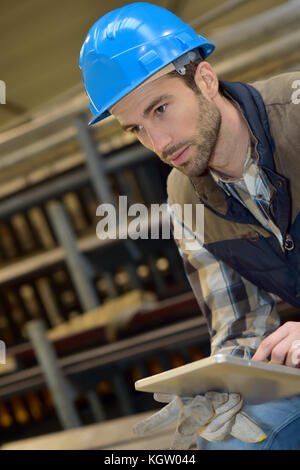 Man in manufacture using digital tablet Stock Photo