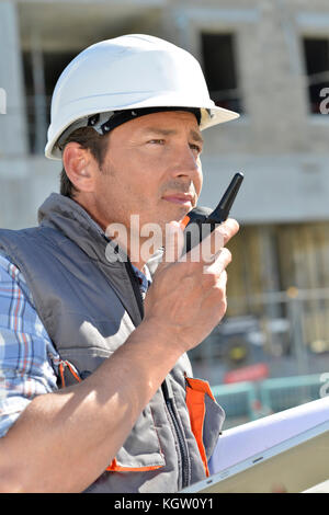 Man on building site using walkie-talkie Stock Photo