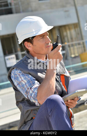 Man on building site using walkie-talkie Stock Photo