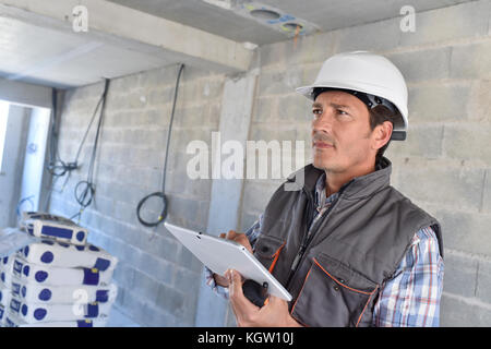Construction manager using tablet on building site Stock Photo