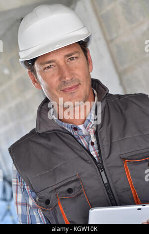 Construction manager using tablet on building site Stock Photo