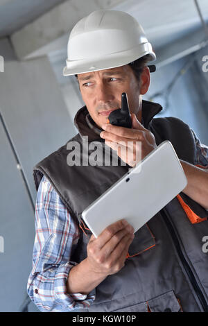 Entrepreneur on building site using walkie talkie Stock Photo
