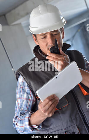 Entrepreneur on building site using walkie talkie Stock Photo