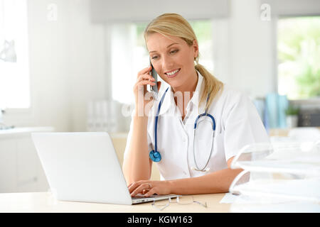 Portrait of doctor in office talking on phone Stock Photo