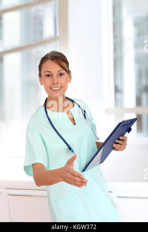 Beautiful nurse giving handshake to patient's family Stock Photo