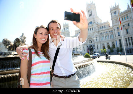 Couple taking pictures in Plaza de Cibeles, Madrid Stock Photo