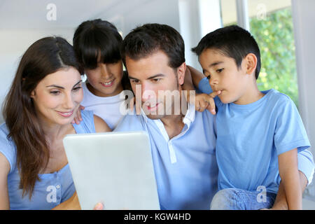 Parents and children using electronic tablet at home Stock Photo