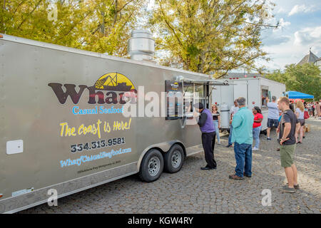 Customers at a food truck festival in a small community in Montgomery Alabama, USA, wait in line, or queue, to order food. Stock Photo