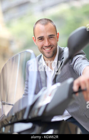Man going to work on motorcycle Stock Photo