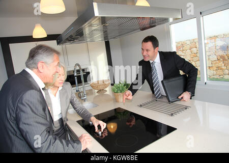 Real-estate agent showing interior of house to senior couple Stock Photo
