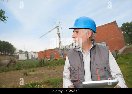 Site manager using electronic tablet Stock Photo