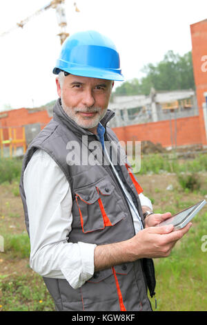 Site manager using electronic tablet Stock Photo