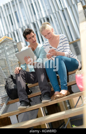 Students in school yard using digital tablet Stock Photo