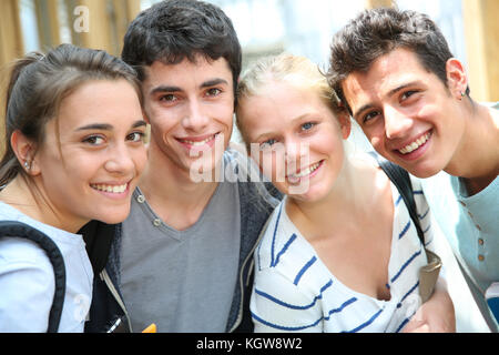 Cheerful students standing outside school building Stock Photo