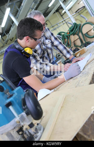 Carpenter with apprentice in training period Stock Photo