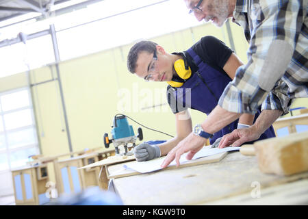 Carpenter with apprentice in training period Stock Photo